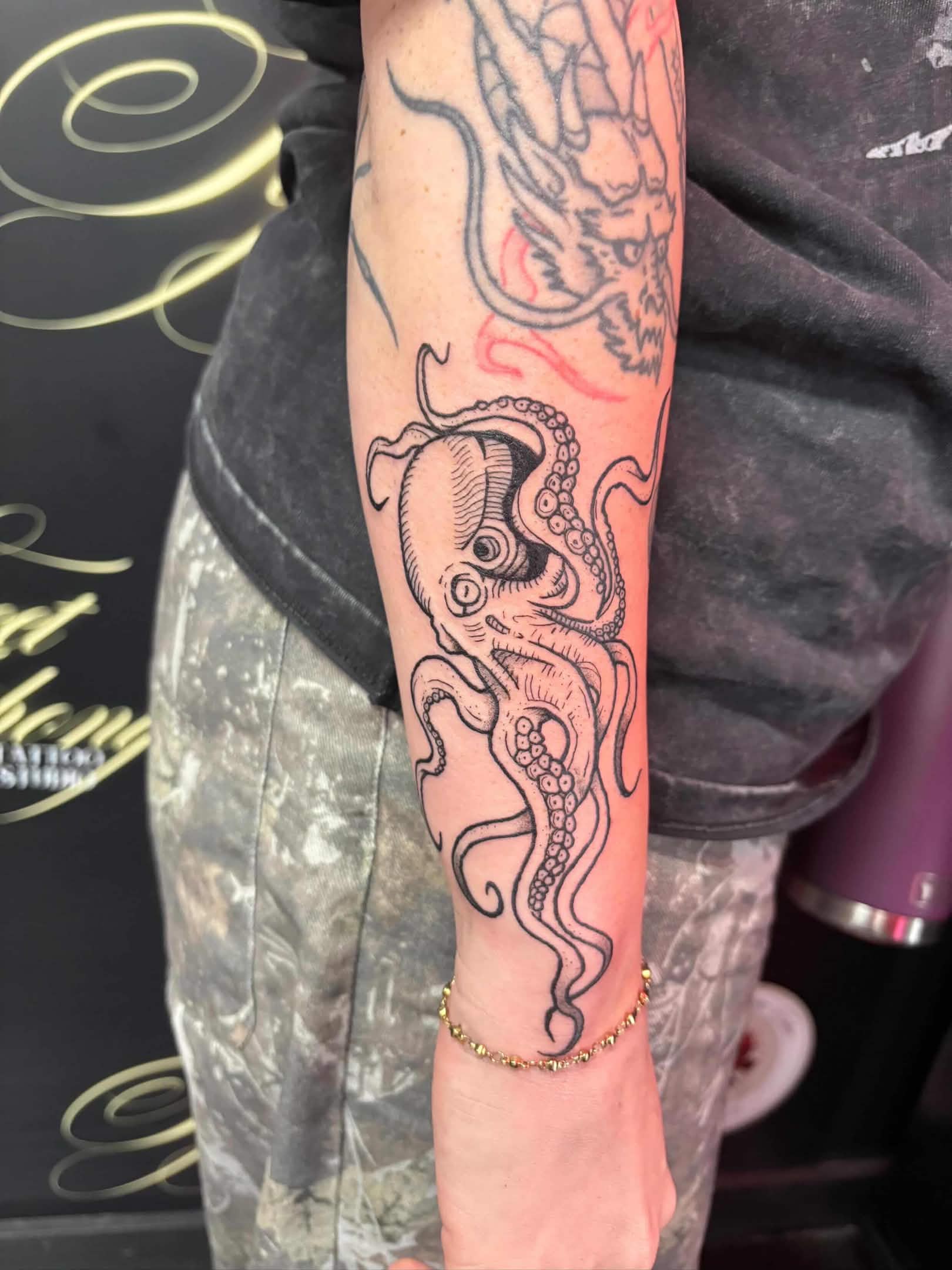 Bold blackwork octopus tattoo with dotwork shading on the forearm.